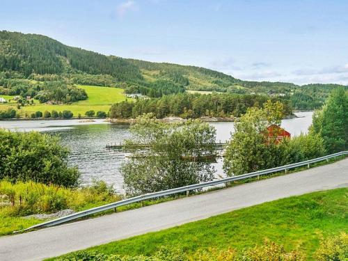 a road next to a river with a mountain at 8 person holiday home in VÅGLAND-By Traum in Vågland