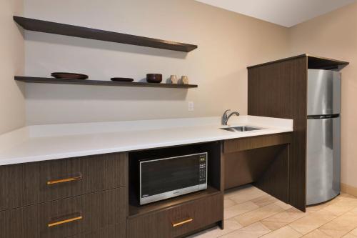 a kitchen with a sink and a microwave at Hotel Indigo Rochester - Mayo Clinic Area in Rochester