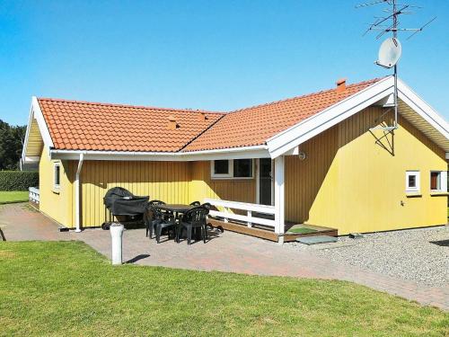 una casa amarilla con una mesa y sillas frente a ella en 6 person holiday home in Nordborg, en Nordborg