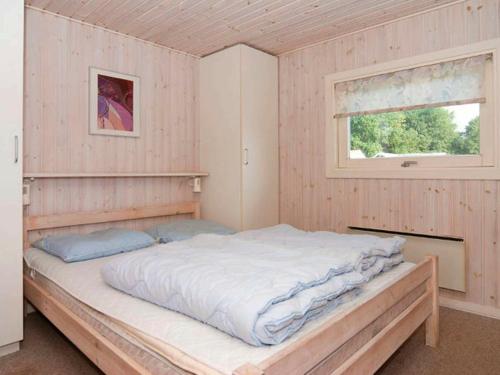 HejlsにあるThree-Bedroom Holiday home in Sjølund 4の窓付きの客室の大型ベッド1台分です。