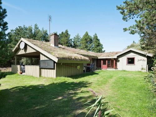 uma casa velha com um telhado de relva e um quintal em 6 person holiday home in R m em Bolilmark