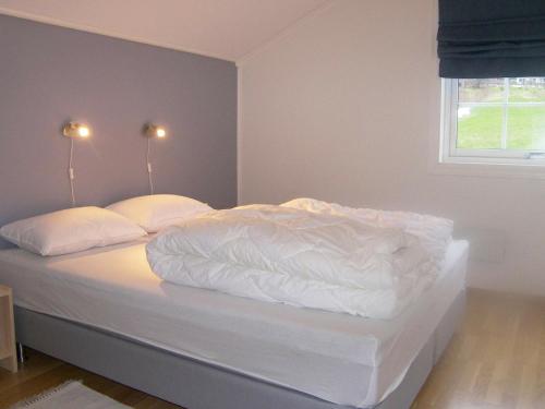 1 dormitorio con 1 cama con sábanas y almohadas blancas en Two-Bedroom Holiday home in Leikanger, en Leikanger
