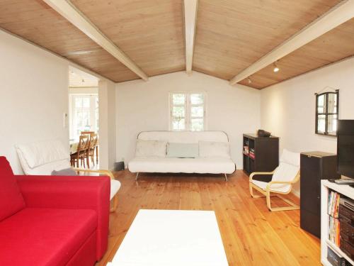 Jægersprisにある9 person holiday home in J gersprisのリビングルーム(赤いソファ、ベッド付)