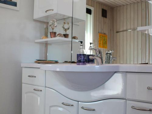 uma casa de banho com um lavatório e um espelho em Three-Bedroom Holiday home in Vejby 14 em Blåvand