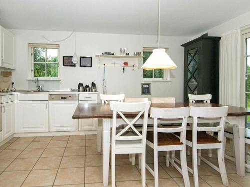 a kitchen with a wooden table and white cabinets at 8 person holiday home in Gjern in Gjern