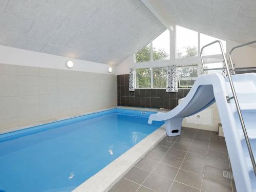 - une piscine avec toboggan dans la salle de bains dans l'établissement 18 person holiday home in Bl vand, à Blåvand