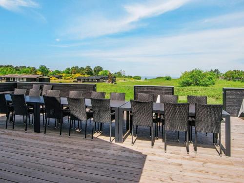 a patio with a table and chairs on a deck at 20 person holiday home in Glesborg in Glesborg