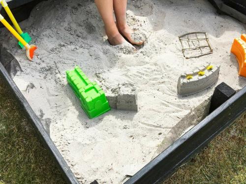 a child playing in a sandbox in a sand trap at 10 person holiday home in Jerup in Jerup