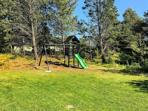 a playground with a green slide in the grass at 10 person holiday home in Jerup in Jerup