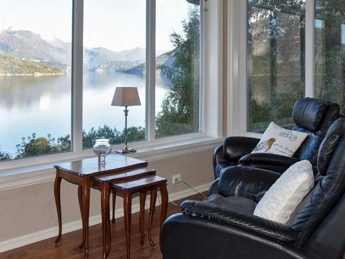 a living room with a chair and a table and large windows at 10 person holiday home in Folkestad in Folkestad