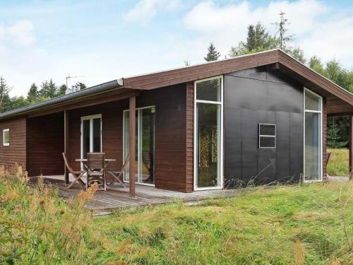 Fjerritslevにある8 person holiday home in Fjerritslevの木製デッキ付きの小さな黒い家