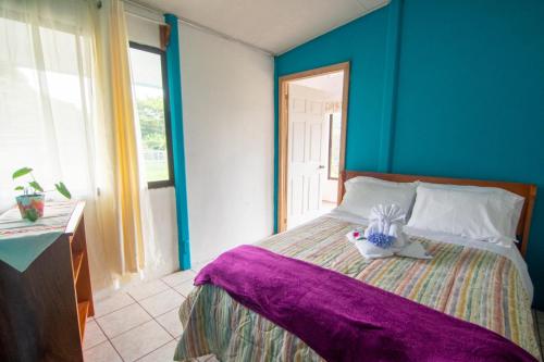 a bedroom with a bed with a stuffed animal on it at Lidia's Mountain View Vacation Homes in Monteverde Costa Rica