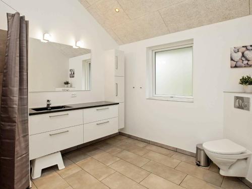 a white bathroom with a toilet and a sink at Luxury Retreat with Pool - By Traum Ferienwohnungen in Gørlev