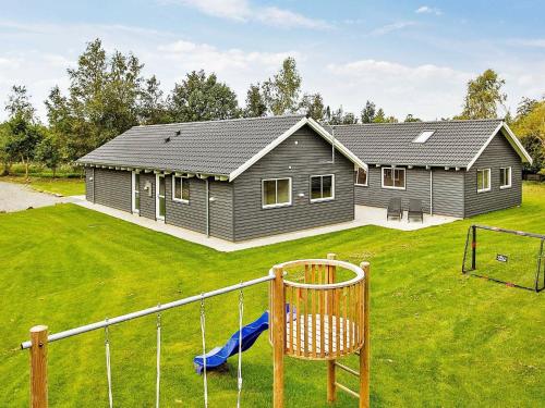 a house with a playground in front of it at 18 person holiday home in H jby in Højby