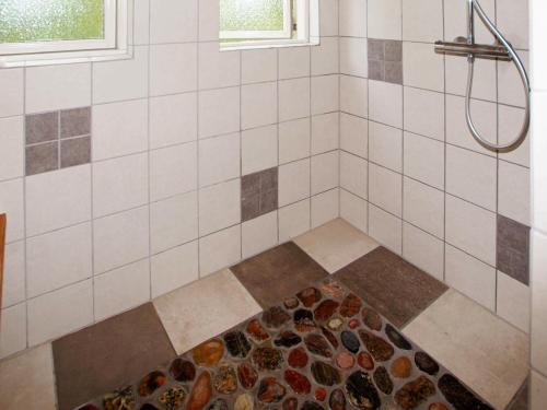 a bathroom with a shower with rocks on the floor at 8 person holiday home in Hemmet in Hemmet