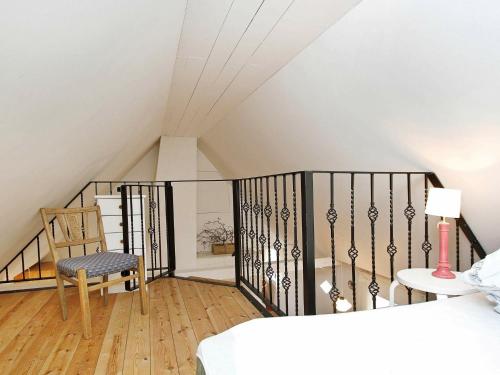 ブラーバンドにあるOne-Bedroom Holiday home in Blåvand 3のベッドと椅子付きの屋根裏部屋