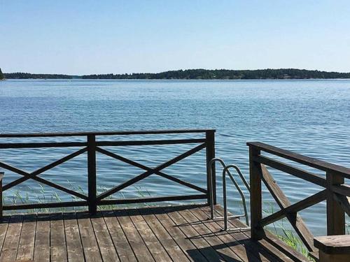 a wooden pier with a fence and the water at 4 person holiday home in KERSBERGA in Åkersberga