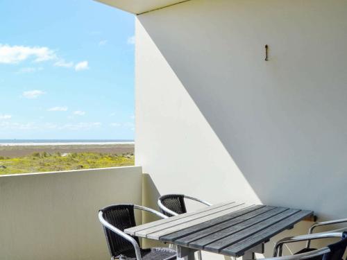 a table and chairs on a balcony with a view of the ocean at 4 person holiday home in Fan in Fanø