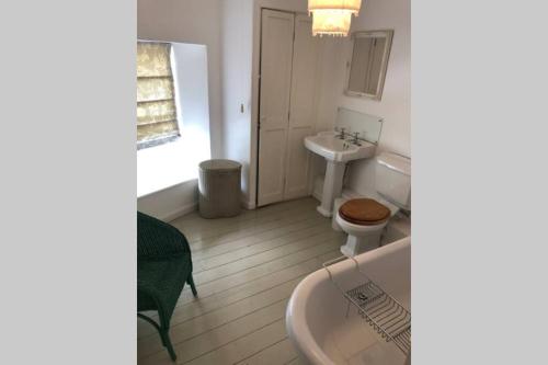 a bathroom with a sink and a toilet and a tub at Leatside Cottage in Port Isaac