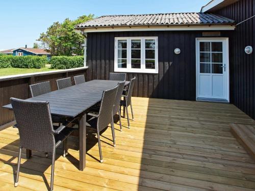 a wooden deck with a table and chairs on a house at 8 person holiday home in Hemmet in Hemmet