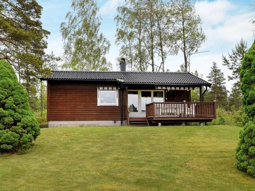 a small house with a deck and a yard at 4 person holiday home in Frändefors in Stora Lövnäs