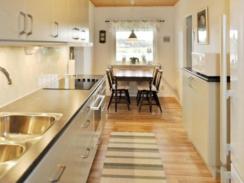 a kitchen with a table and chairs in it at 4 person holiday home in Frändefors in Stora Lövnäs