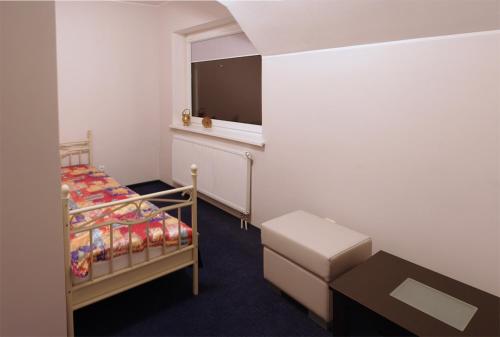 niewielka sypialnia z łóżkiem i oknem w obiekcie Luka w Mariampolu
