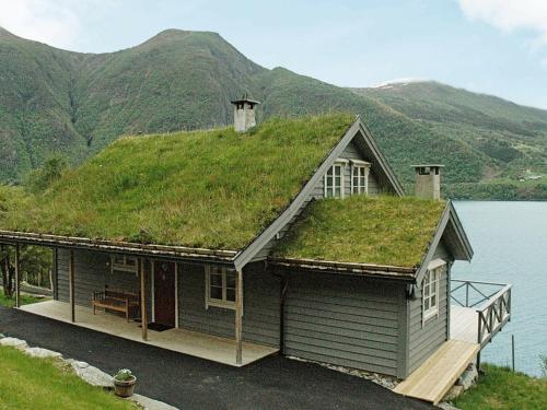 a house with a grass roof on top of a lake at 11 person holiday home in Lauvstad in Åmelfot