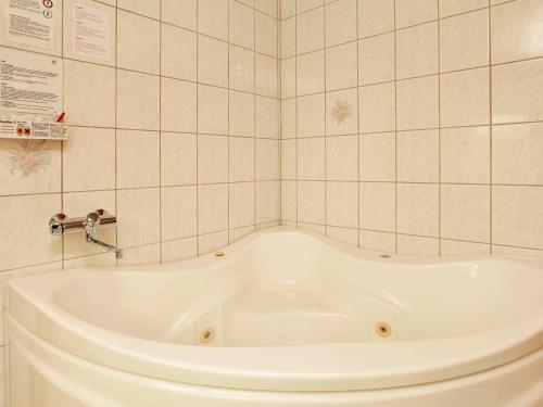 a white bath tub in a tiled bathroom at 6 person holiday home in Hemmet in Hemmet