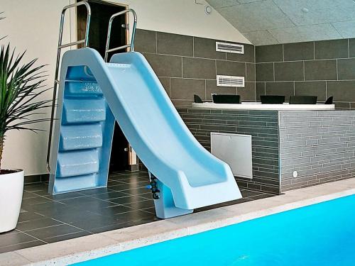 a blue slide next to a swimming pool at 14 person holiday home in Stege in Stege