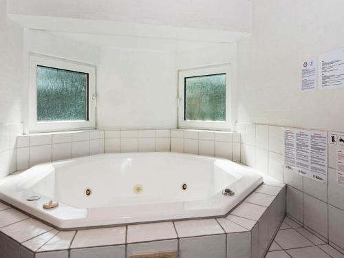 baño con bañera blanca y 2 ventanas en 6 person holiday home in Fan, en Fanø