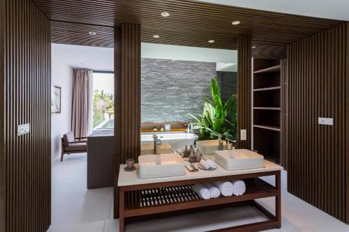 a bathroom with two sinks and a large mirror at Naman Retreat in Da Nang