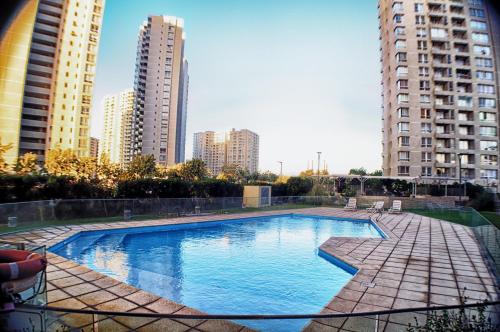 ein Schwimmbad in einer Stadt mit hohen Gebäuden in der Unterkunft Hermoso departamento a pasos de playa Peñuelas La Serena in Coquimbo