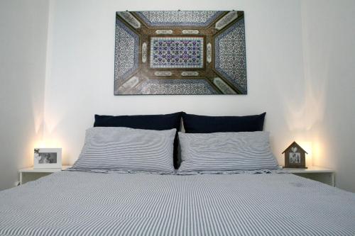 a bedroom with a bed with a painting above it at Villa Giulia in Ostuni