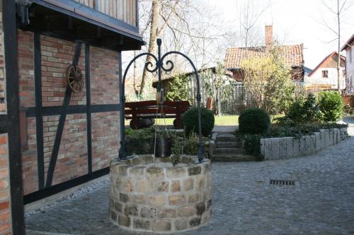 a fountain in front of a brick building with a bench at Harz-Chill Wernigerode in Wernigerode