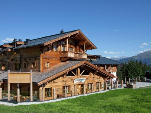 a large wooden building with a balcony on it at Holiday home with snow covered views in Hollersbach im Pinzgau