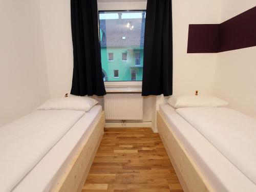 2 Betten in einem Zimmer mit Fenster in der Unterkunft Cozy Apartment near Ski Area in Eisenerz in Eisenerz