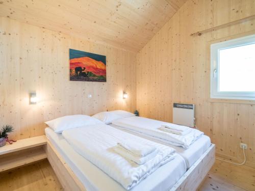 ザンクト・ローレンツェン・オプ・ムーラウにあるScenic Chalet in Sankt Georgen on Ski Slopesの木製の部屋に大型ベッドが備わるベッドルーム1室が備わります。