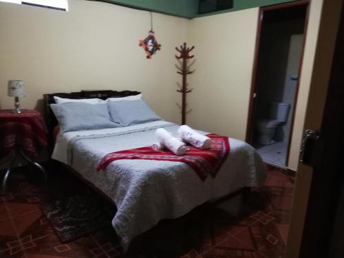 a bedroom with a bed with two towels on it at Artesonraju Hostel Huaraz in Huaraz