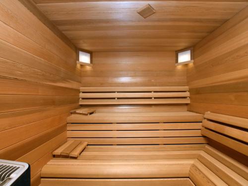 a sauna with wooden walls and floors and two windows at Luxurious Home with Sauna in Somme-Leuze