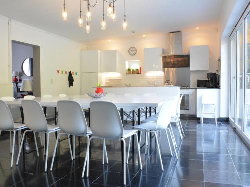 cocina y comedor con una gran mesa blanca y sillas en Spacious Holiday Home with Private Terrace en Denée