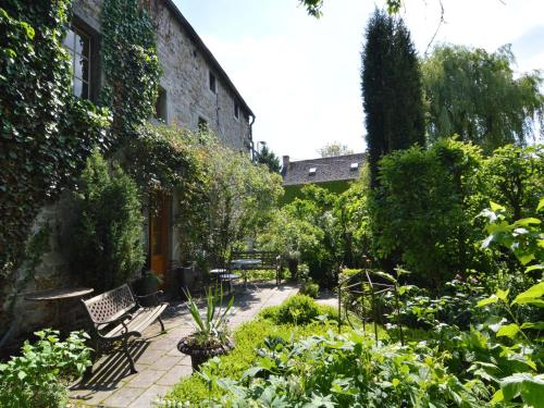 um jardim com cadeiras e plantas ao lado de um edifício em Enchanting Cottage with Terrace Garden em Hamoir