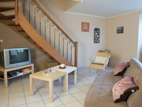 sala de estar con sofá y TV en Renovated Cottage in Corn mont with Garden en Louveigné