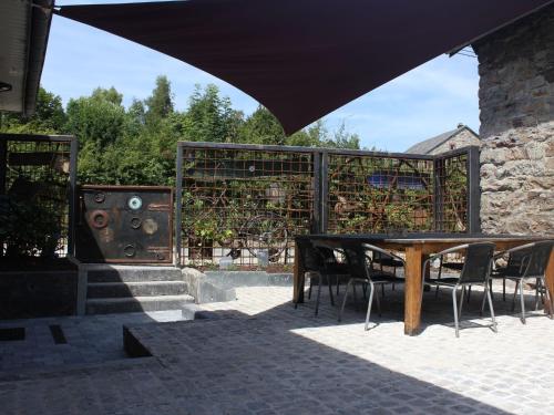 a wooden table and chairs in a patio at Gorgeous Holiday Home in Ovifat with Sauna in Waimes