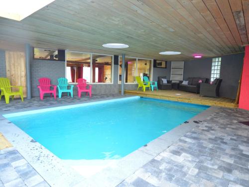 una piscina con sillas coloridas y un sofá en A House with pool sauna bubble bath billiards, en Trooz