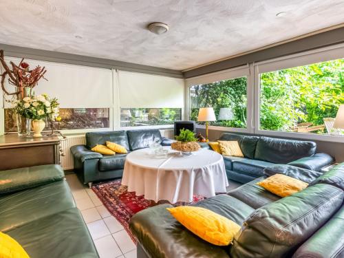 een woonkamer met banken en een tafel bij Holiday Home with Terrace Garden Parking in Uikhoven