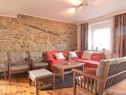 AmblèveにあるCaptivating Apartment in Halenfeld Amel with Terraceのリビングルーム(赤いソファ、椅子付)