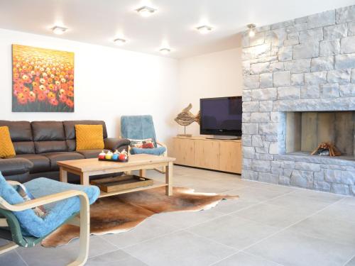 ein Wohnzimmer mit einem Sofa und einem Kamin in der Unterkunft Tasteful Holiday Home in Waimes with Sauna in Ovifat