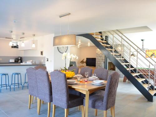 a dining room with a table and chairs and a staircase at Tasteful Holiday Home in Waimes with Sauna in Ovifat