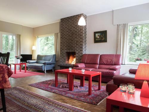 sala de estar con muebles de color rojo y chimenea en This atmospheric holiday home en Zoersel